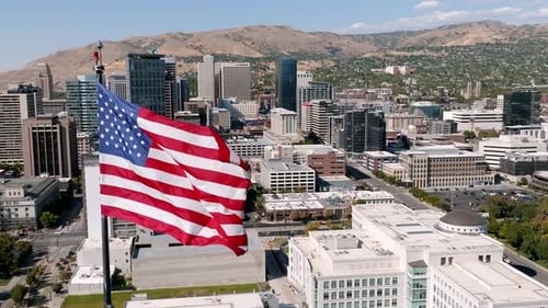 American Flag Waving Over City, Aerial View