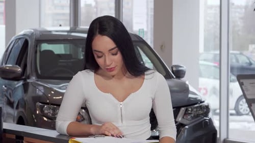 Woman Smiling and Holding Car Keys in Dealership