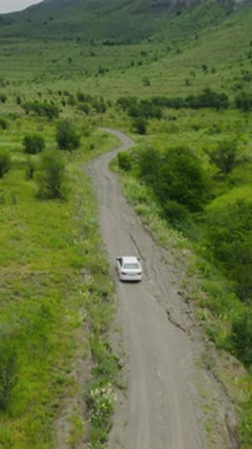Top View of Car Driving on Road Near Green Mountains Action Beautiful Car Ride Through Mountain