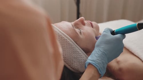Professional Cosmetologist Performing Dermapen Treatment