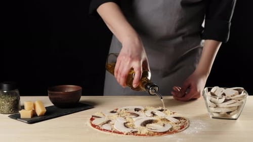 Woman Preparing Mushroom Pizza with Olive Oil