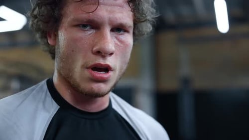 Portrait of Tired Fighter Standing in Fitness Center. Closeup Exhausted Sportsman Looking