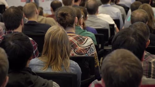 Audience Sitting in Conference Room at Corporate Event