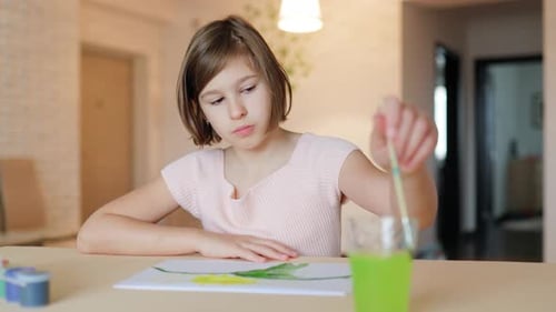 Girl Painting With Watercolors at Home on a Table