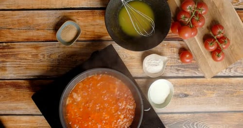 Tomato Sauce Simmering on Wooden Kitchen Table