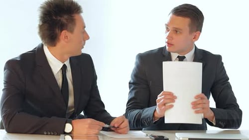 Businessmen Concluding a Discussion As One Picks Up Important Documents