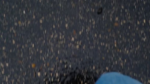 Blick von oben auf die Laufbeine auf nassem Asphalt nach Regen, Frühlingsstimmung. Sportliches Schuhwerk und stylisches