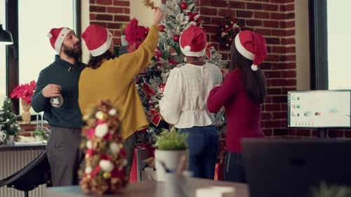 Team Decorating Christmas Tree in Urban Office