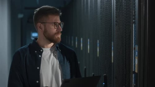 Young Skilled Data Center Administrator Using Laptop at Work