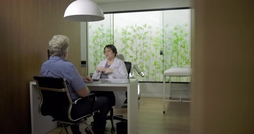 Man Talking with Doctor in Modern Medical Office