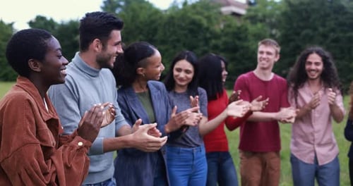 Group of Young Adults Clapping and Smiling Outdoors
