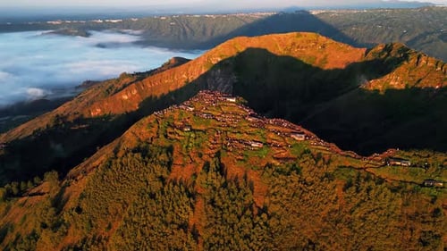 Randonneurs regardant le lever du soleil sur la crête volcanique du mont Batur au-dessus d'une mer de nuages Vue aérienne cinématographique