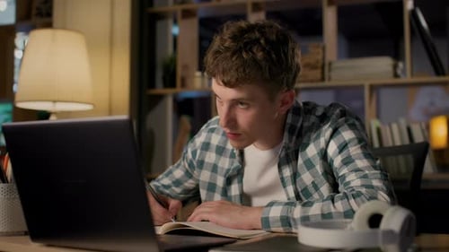 Online Education of University Student Using Laptop in Evening Room. Remote Study