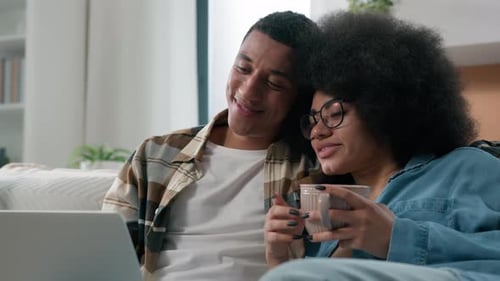 Couple Relaxing Together on Sofa With Laptop
