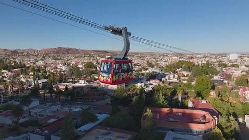 Colorful Cable Car Gondola Traveling Over Mexican City with Mountain Views