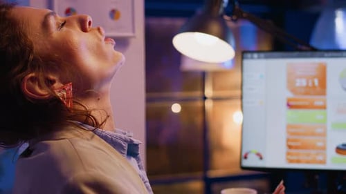 Businesswoman Sipping Coffee While Working Late at Computer