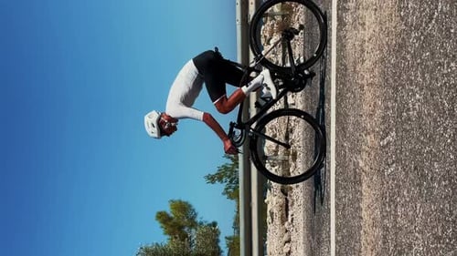 Athlete Riding Bicycle on Road Near Beach