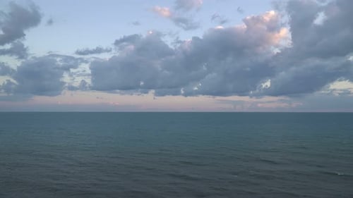 Mar o océano tranquilos y grandes nubes por la noche al atardecer