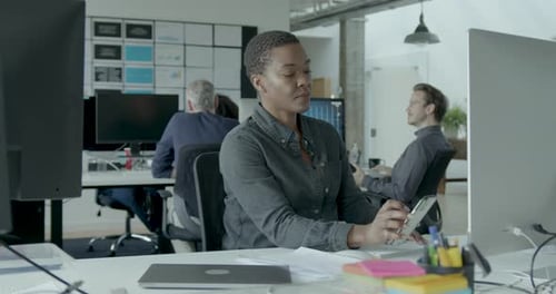 Young African American Businesswoman Working at a Desktop computer in an Office