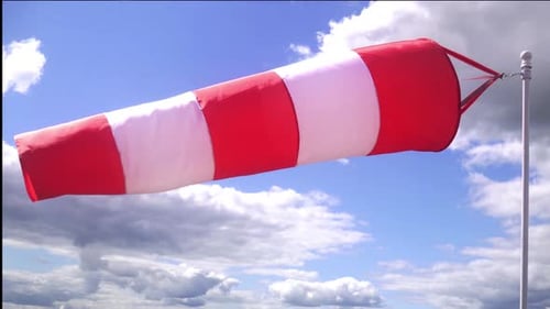 Cone Shaped Windsock Waving In The Wind Under The Clouds.