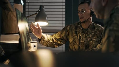 Military Personnel Analyzing Data in a Dark Room