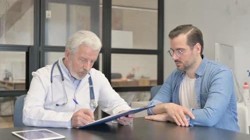 Doctor Reviewing Form with Patient at Clinic Table