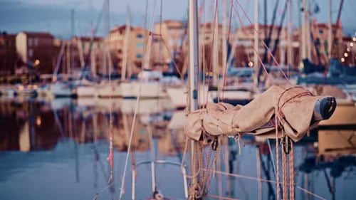 View from the deck of a sailboat moored in a marina on the French Riviera, with masts and waterfront