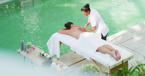 Woman Receiving Relaxing Back Massage at Tropical Spa