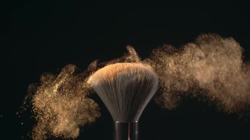 Superzeitlupen-Makroaufnahme von Make-up-Pinsel und goldglänzendem Gesichtspudershake mit 1000 Bildern pro Sekunde, elegant