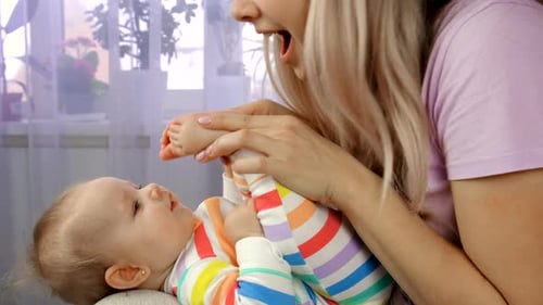 Mother and Infant Playing with Feet at Home
