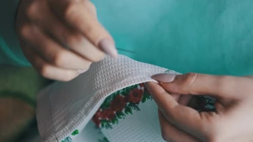 Person Sewing a Patterned Cloth, Close Up