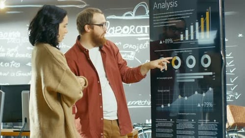 Entwicklerin und männlicher Manager verwenden den interaktiven Whiteboard-Präsentations-Touchscreen, um sich Ch anzusehen
