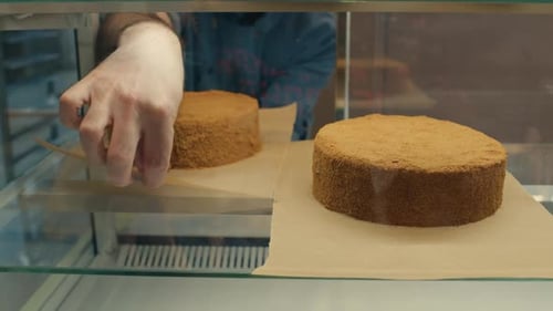 Bakery Worker Placing Cake on Display Shelf