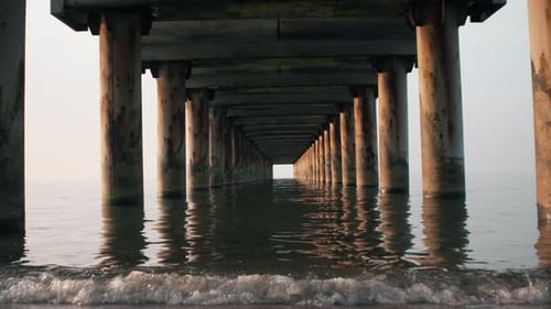 Sea view under the pier at sunset