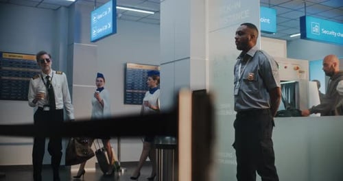 Airport Terminal Airline Captain and Two Stewardesses in Uniforms Walking with Suitcases for Flight