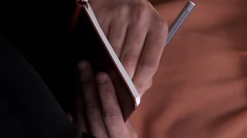 Hands Holding Notepad With Silver Pen Close Up