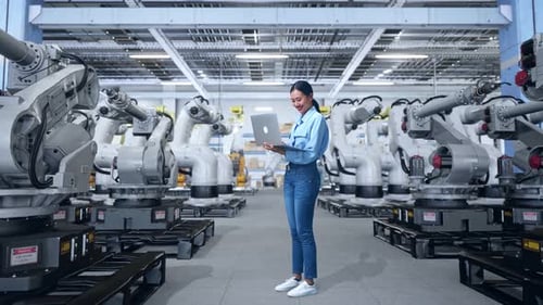 Robotics Factory with Worker Using Laptop