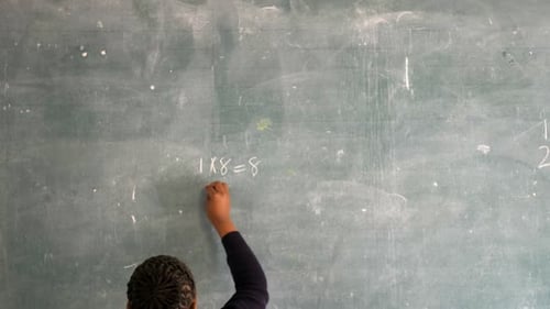 Student Writes Multiplication Equations on Chalkboard