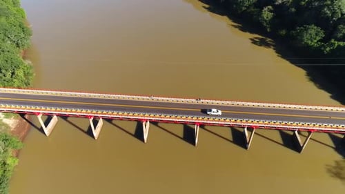 Image prise par drone montrant un magnifique pont enjambant une rivière boueuse.