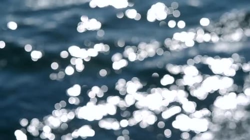 Abstrakter Meeresblick auf das blaue Meer mit Wellen auf dem Wasser und weißem Sonnenschein