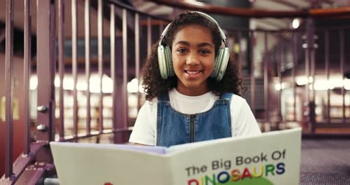 Library, face and child with headphones, book and happy to learn with literature