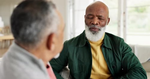 Two Mature Men Talking and Smiling Indoors