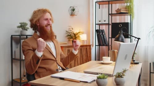 Young Adult Celebrates Success at Desk