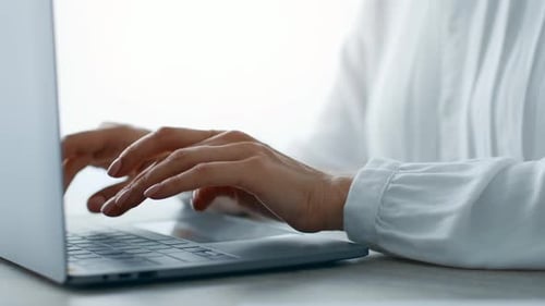 Professionelle Frau, die tagsüber in einer modernen Büroumgebung am Laptop arbeitet