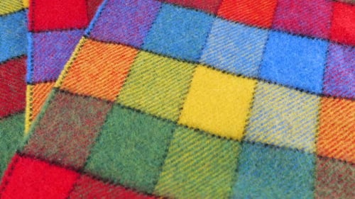 Top view on the bright textured multicolored wool fabric in a large check rotated