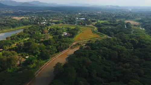Aerial View of a River Winding Through a Rural Landscape Alongside Farmland and Dense Forests