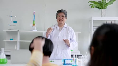 Close-up teacher standing in front class teaching students in science classroom, teacher's face