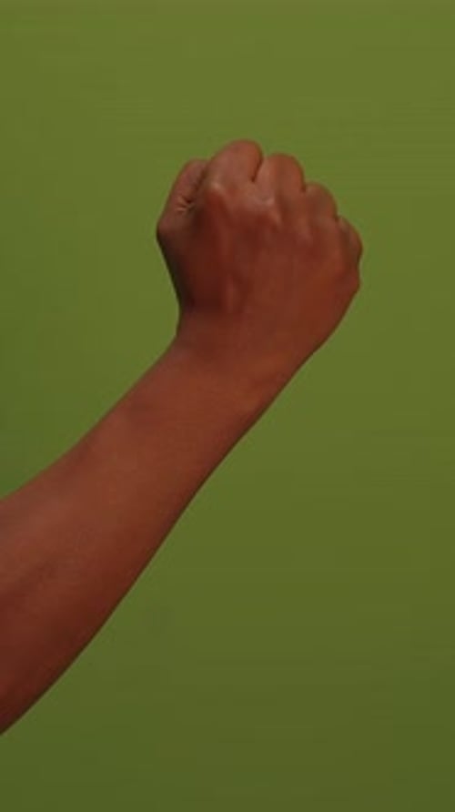 Fist Symbolizing Unyielding Strength Set Against a Bold Green Background for Impact