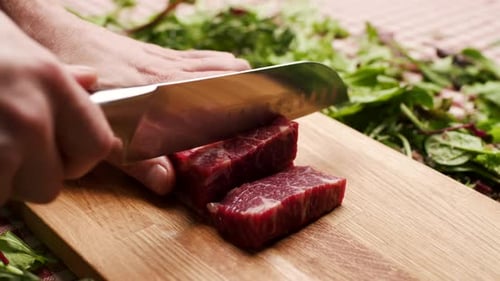 Chef Cutting Raw Meat on a Wood Board
