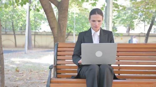 Businesswoman Shocked by Project Results on Laptop Outdoor
